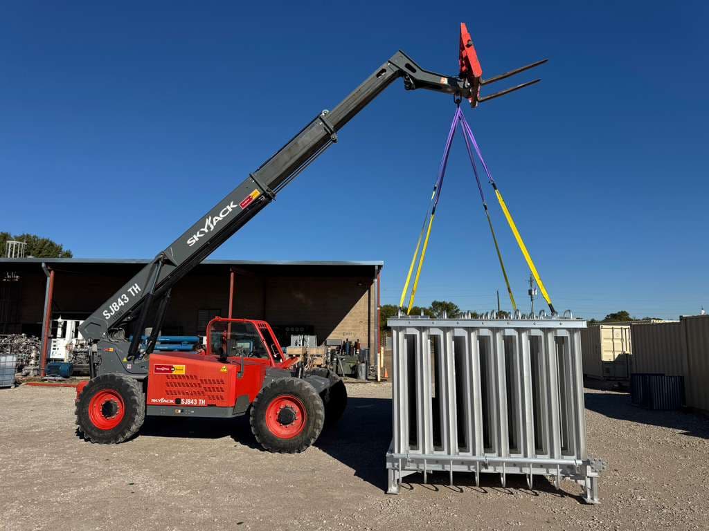 SkyJack telehandler lifting decommissioned vaporizer bank at facility yard