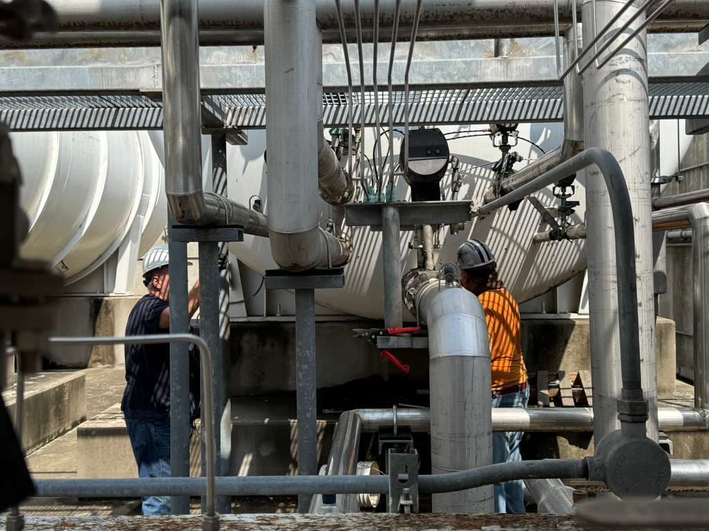 Technicians working on cryogenic piping infrastructure